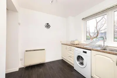 a kitchen with a sink and a washing machine at Edinburgh Morningside 2-Bedroom Apartment - Ground Floor in Edinburgh
