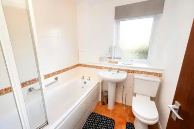 a bathroom with a tub and a sink and a toilet at Edinburgh Morningside 2-Bedroom Apartment - Ground Floor in Edinburgh