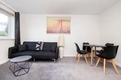 a living room with a couch and a table at Edinburgh Morningside 2-Bedroom Apartment - Ground Floor in Edinburgh