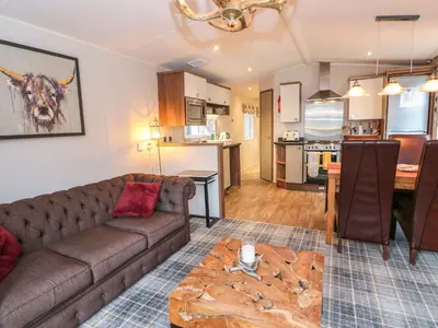 a living room with a couch and a kitchen at Loch Lomond Holiday home in Arrochar