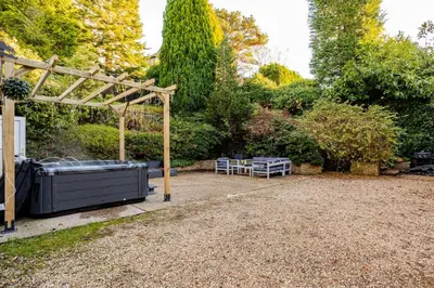 a garden with a fountain and a pergola at Edwardian Manor hot tub & Pool in Glasgow, Gated in Giffnock