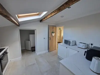 a kitchen with white cabinets and a refrigerator at The Old school House in Moffat