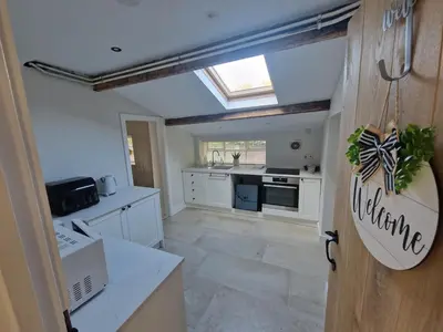 a kitchen with white cabinets and a skylight at The Old school House in Moffat