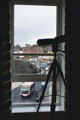 a camera in front of a window with a bus at Littlebay Penthouse in Oban