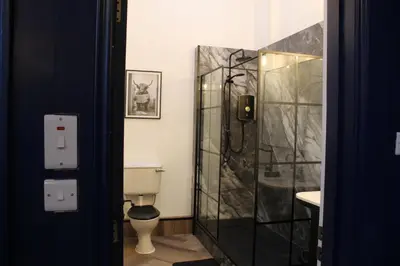 a bathroom with a toilet and a glass shower at 89A Bank Street 3 bedroom in Jamestown