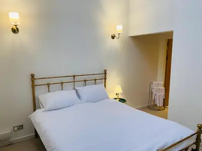 a bedroom with a bed with white sheets and two lights at Cozy Room in Glasgow in Glasgow