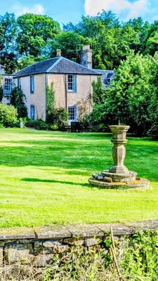 a large house with a statue in the middle of a yard at Estate Getaway at Powis House Estate in Stirling