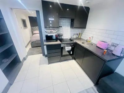 a small kitchen with a sink and a bed at 96 Glasgow road in Newbridge