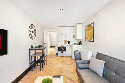 a living room and kitchen with a couch and a table at Newly Renovated 1BR Steps from Hove Beach in Moffat
