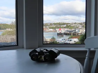 a table with binoculars on it in front of a window at Inveree in Oban