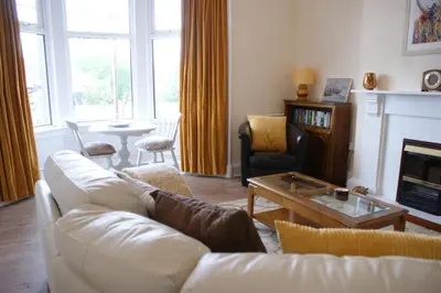 a living room with a white couch and a fireplace at Inveree in Oban