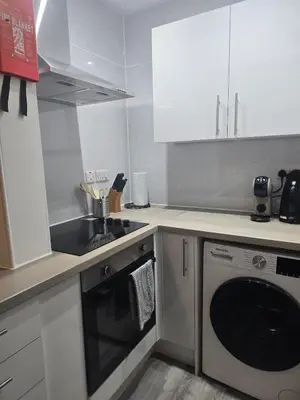 a kitchen with a sink and a washing machine at Comfy Semi-Central Stay near Entertainment Park in Edinburgh