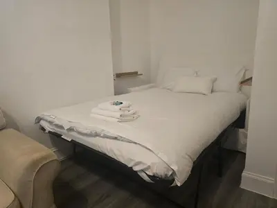 a bed with towels on it in a room at Comfy Semi-Central Stay near Entertainment Park in Edinburgh
