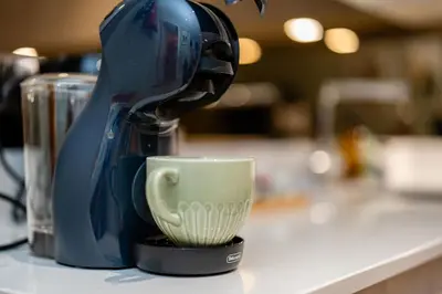 a blue mixer sitting on a counter with a cup at Dragon Suites Luxury Apartments at Rutland Square in Edinburgh
