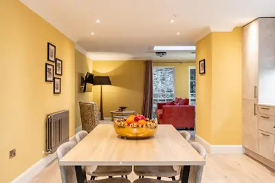 a living room with a table with a bowl of fruit on it at Dragon Suites Luxury Apartments at Rutland Square in Edinburgh