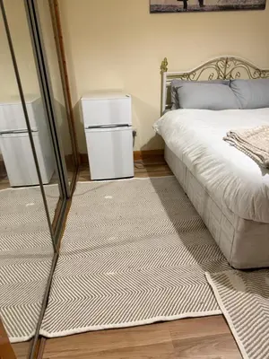 a bedroom with a bed and a small refrigerator at Happy home stay in Cowlairs