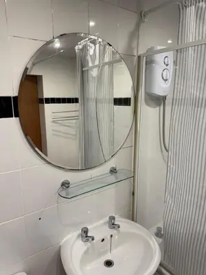 a bathroom with a mirror and a sink at Happy home stay in Cowlairs