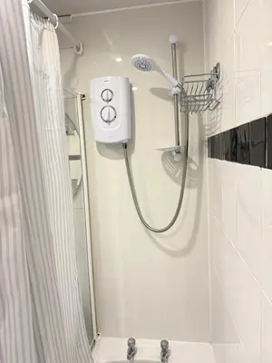 a shower with a shower head in a bathroom at Happy home stay in Cowlairs