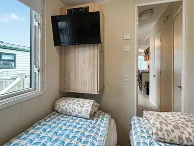 a small room with a bed and a flat screen tv at Ali B's Craig Tara in Ayr