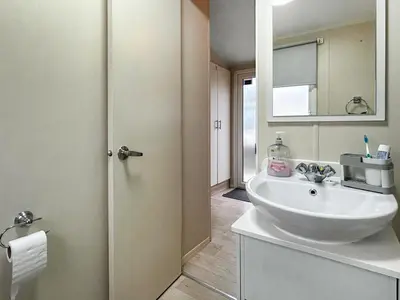 a bathroom with a white sink and a mirror at Ali B's Craig Tara in Ayr