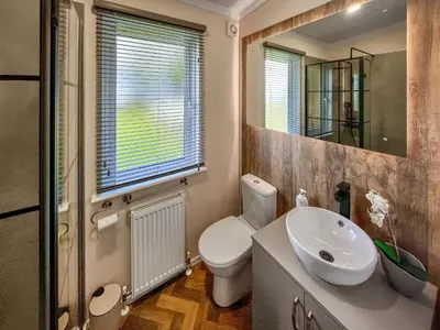 a bathroom with a sink and a toilet and a mirror at Woodland View in Auchterarder