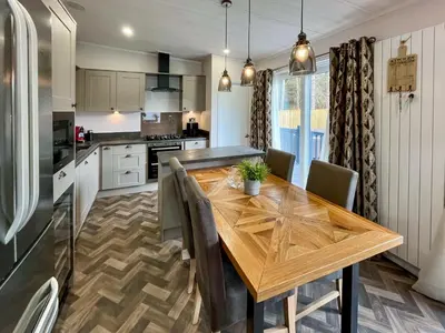 a kitchen with a wooden table and a dining room at Woodland View in Auchterarder
