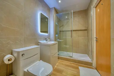 a bathroom with a toilet and a shower and a sink at Modern Luxe Apartment in Glasgow City Centre in Glasgow