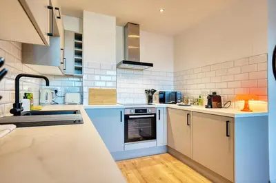 a large kitchen with blue and white appliances at Modern Luxe Apartment in Glasgow City Centre in Glasgow