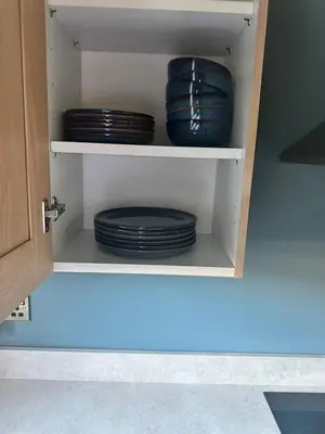 a cupboard filled with blue bowls and plates at The Skipper's Rest in Millport