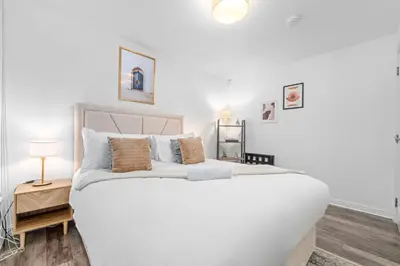 a bedroom with a large white bed and a table at Urban Elegance - Spacious 5-Bed Home in Glasgow in Glasgow