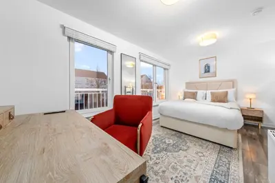 a bedroom with a bed and a red chair at Urban Elegance - Spacious 5-Bed Home in Glasgow in Glasgow