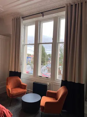 a living room with two chairs and a table and a window at The Graeme Hotel in Falkirk
