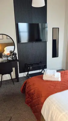 a bedroom with a bed and a desk and a mirror at The Graeme Hotel in Falkirk