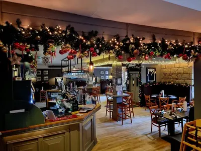 a restaurant with tables and chairs and christmas decorations at The Graeme Hotel in Falkirk