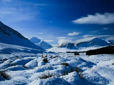 a snow covered mountain with mountains in the background at Glenbruar House in Crianlarich