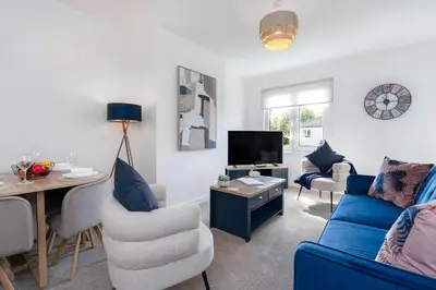 a living room with a blue couch and a table at Fraser Apartment- 2 Bedrooms Inverleith, Edinburgh in Edinburgh