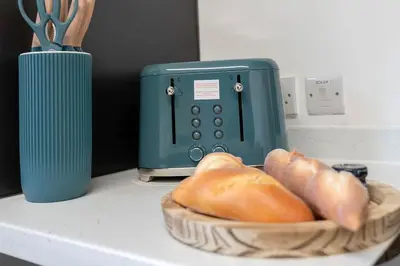 a basket of bread sitting next to a toaster at Fraser Apartment- 2 Bedrooms Inverleith, Edinburgh in Edinburgh
