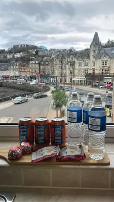 a group of bottles of water and cupcakes on a table at Bay View Apartment in Oban