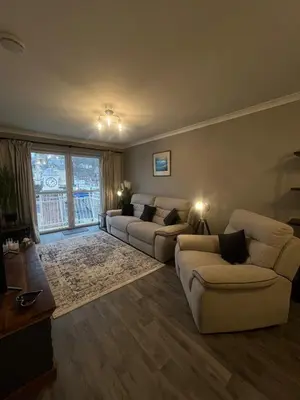 a living room with two couches and a large window at Bay View Apartment in Oban