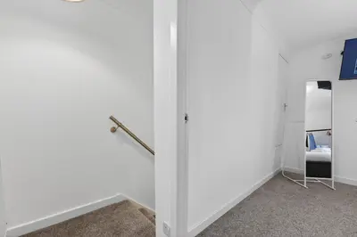 a room with a white wall and a door at The Hide - Suburban Terraced Home in Horse Isle