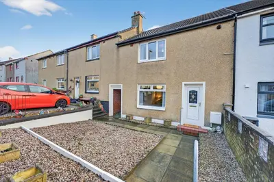 a brick house with a red car parked in front of it at The Hide - Suburban Terraced Home in Horse Isle