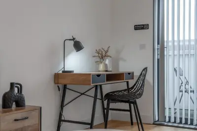 a desk with a chair and a desk with a lamp at Modern 2-Bed Flat with Balcony and Free Parking - Ideal for Contractors in Moffat