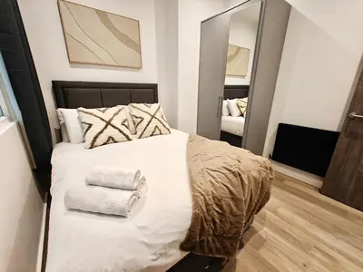 a bedroom with a bed with towels on it at Bright 2-Bed Apartment in Bury Town Centre in Moffat
