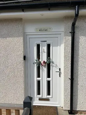 a white door with a flower wreath on it at Canal View Cottage in Winchburgh