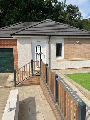 a house with a wooden fence and a gate at Canal View Cottage in Winchburgh