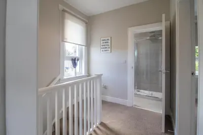 a white room with a staircase and a window at Pinkerton House - 3 bed Rutherglen in Glasgow