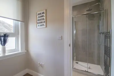 a bathroom with a shower with a glass door at Pinkerton House - 3 bed Rutherglen in Glasgow