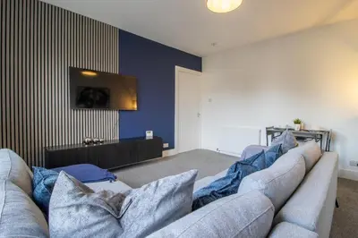a living room with a couch and a tv at The Wishy - 2 Bedroom Flat in Newmains in Newmains