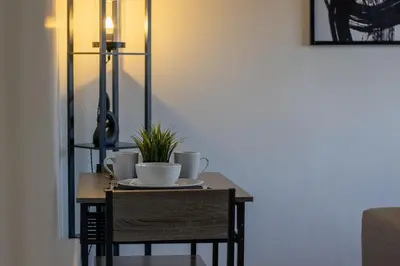 a table with two cups and a plant on it at The Wishy - 2 Bedroom Flat in Newmains in Newmains