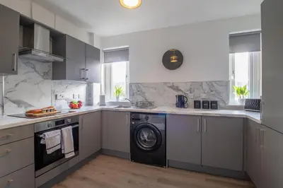 a kitchen with a washer and a washing machine at The Wishy - 2 Bedroom Flat in Newmains in Newmains